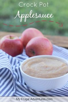 a bowl of crock pot applesauce next to some apples on a table