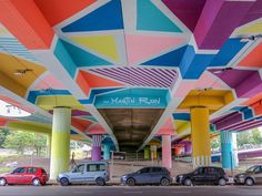 several cars parked under a multicolored structure