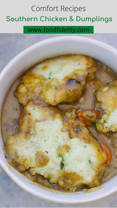 a white bowl filled with chicken and dumplings covered in gravy on top of a table