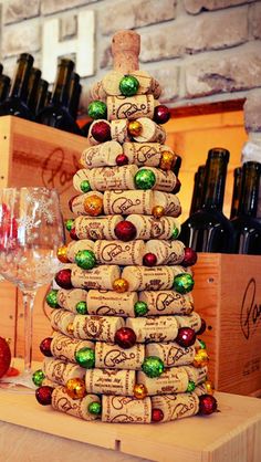 a christmas tree made out of wine corks on top of a wooden table next to bottles