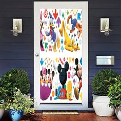 mickey mouse and friends door stickers on the side of a house with potted plants