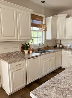 a kitchen with marble counter tops and white cabinets