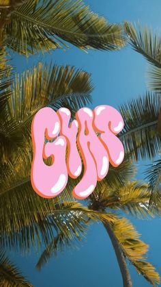 a pink sticker that says kiss on the side of a palm tree in front of a blue sky