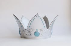 a silver and blue crown on a white surface