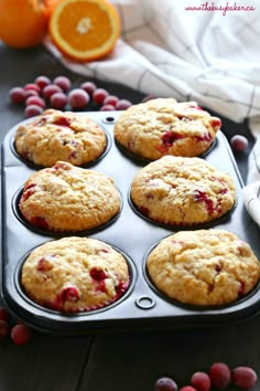 muffins with cranberries and oranges in the background on a tray