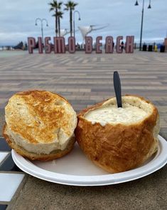 a sandwich on a plate with a knife sticking out of it's center and the beach in the background