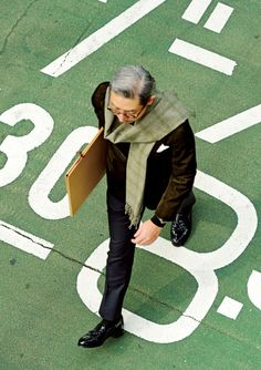 an overhead view of a man in business attire holding a folder and looking down at the ground