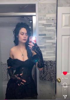 a woman is taking a selfie in the mirror with her cell phone while wearing a black corset