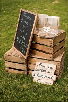 wooden crates stacked on top of each other in the grass with signs attached to them