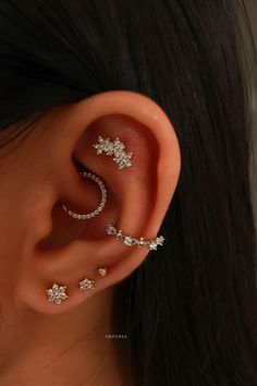 a woman wearing three different ear piercings