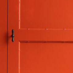 an orange door with a black handle on it