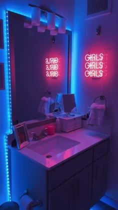 a bathroom with two neon lights on the wall and a sink in the foreground