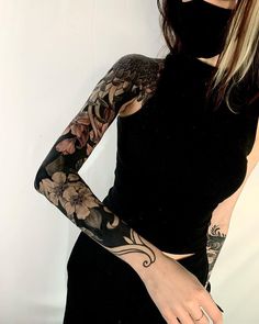 a woman with tattoos on her arm wearing a black top