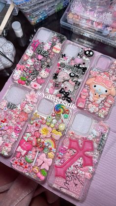 hello kitty phone cases are sitting on a table with other items in the back ground