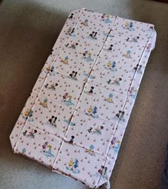 a baby's crib with mickey and minnie mouse sheets on the floor next to it