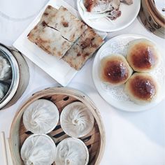 there are many different types of food on the table, including dumplings and cakes