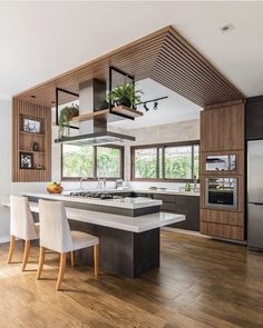 a kitchen with wooden floors and white chairs