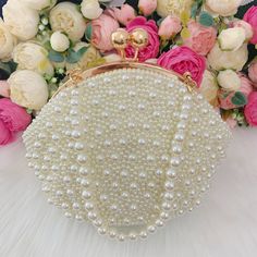 This luxurious encrusted pearl bridal clutch never fails to turn heads with its understated elegance and classic design. Adorned with varying sized White pearls and enhanced with a large creamy pearl clasp, this bridal clutch is the very picture of refinement. This elegant bridal clutch features rose gold trim, attachable chain and large enough for your phone. Complete your list of must-have wedding accessories with the ultimate bridal accessory to finish off your look and storing your wedding d Evening Clutch In Pearl White With Pearl Embroidery, Pearl White Evening Clutch With Pearl Embroidery, Evening Pearl White Clutch With Pearl Embroidery, Gold Clutch With Pearl Embroidery, Gold Pearl Clutch With Pearl Embroidery, Cream Pearl Evening Bag For Party, Beige Pearl Embellished Evening Bag For Wedding, Pearl White Pearl Evening Bag For Events, Pearl White Clutch With Pearl Embroidery For Events