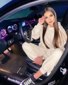 a woman sitting in the driver's seat of a car