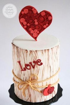 a cake made to look like a tree stump with hearts on top that says love