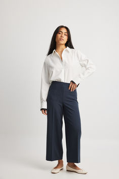 These pants are calf-length and feature a high waist fit and a wide straight leg. They have a stretchy material and an elasticized waistband. Our pants have a concealed side zipper closure. Culotte Outfit, Internship Outfit, Culottes Outfit, Relax Pants, Culotte Pants, High Waist Pants, Cuffed Pants, Cuff Detail, Blue Pants