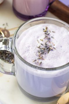 a cup filled with liquid and lavender sprinkles on top of a table