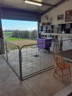 the inside of a garage with a metal fence and purple table in front of it