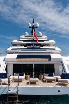 a large white boat in the water with lounge chairs on it's front deck