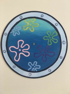 an image of a circular painting on the wall with flowers and bubbles painted on it