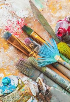 some paint brushes and other art supplies on a table