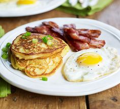 pancakes, bacon and eggs on a white plate