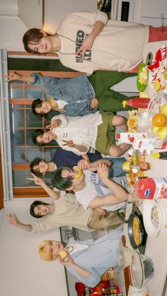 a group of people standing in a kitchen next to each other with food on the counter