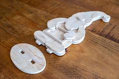 a wooden toy car sitting on top of a wooden floor next to a white object