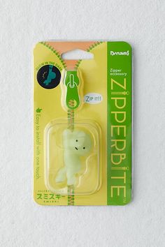 a green and white stuffed animal in a package