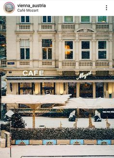 an image of a restaurant in the middle of winter with snow on the ground and tables covered by umbrellas