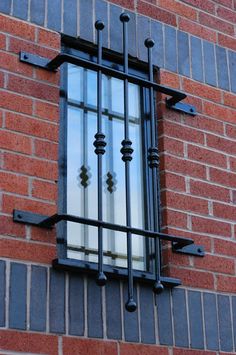 a window with bars on the side of a brick building