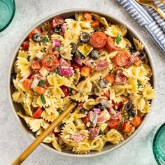 a bowl filled with pasta salad and two wooden chopsticks on top of it