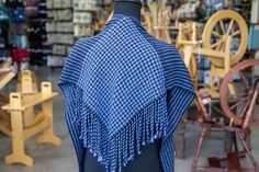 a mannequin wearing a blue shawl with fringes on it's shoulders