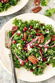 a salad with pecans and feta cheese on top is served in two white plates