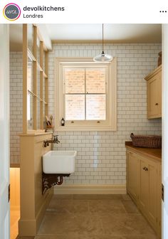 a white sink sitting next to a window in a bathroom on top of a tile floor