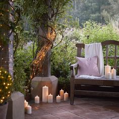 lit candles are on the ground in front of a bench