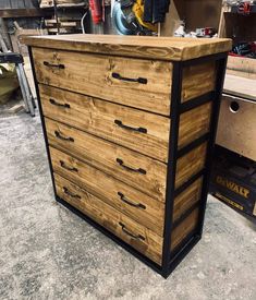 a wooden dresser sitting on top of a floor next to a pile of wood boxes