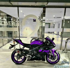 a purple motorcycle parked in front of a building