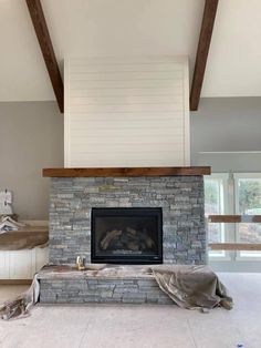 a living room with a stone fireplace and white walls