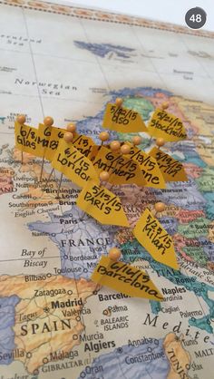 a map with pins pinned to it and the names of countries marked in yellow tape