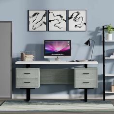 a desk with two drawers and a computer on it in front of a blue wall