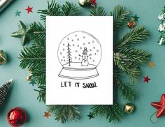 a snow globe card with the words let it snow on it surrounded by christmas decorations