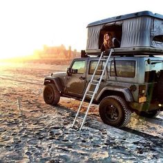 a jeep with a ladder up to the roof