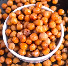 a white bowl filled with chickpeas sitting on top of a black countertop