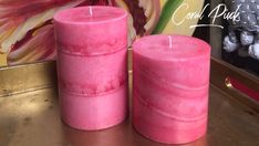 two pink candles sitting next to each other on a table